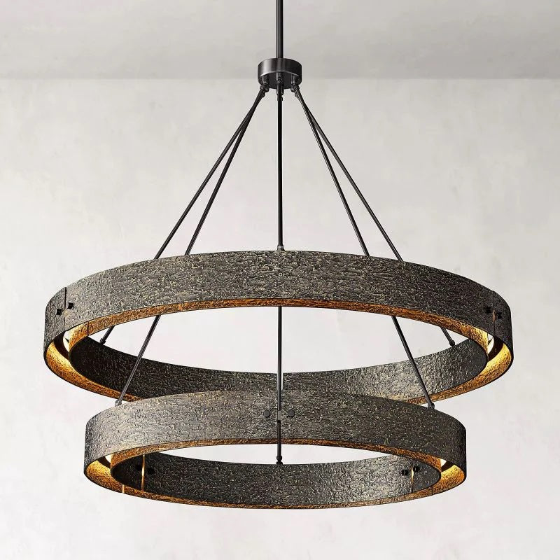 This collection of modern sculptural lighting is centered around solid brass that is cast in hand-formed molds, creating intricate and sensual textures that shape the minimalist geometry of the surface. The chandelier glow is moody and atmospheric, showcasing the beauty of modern living rooms.