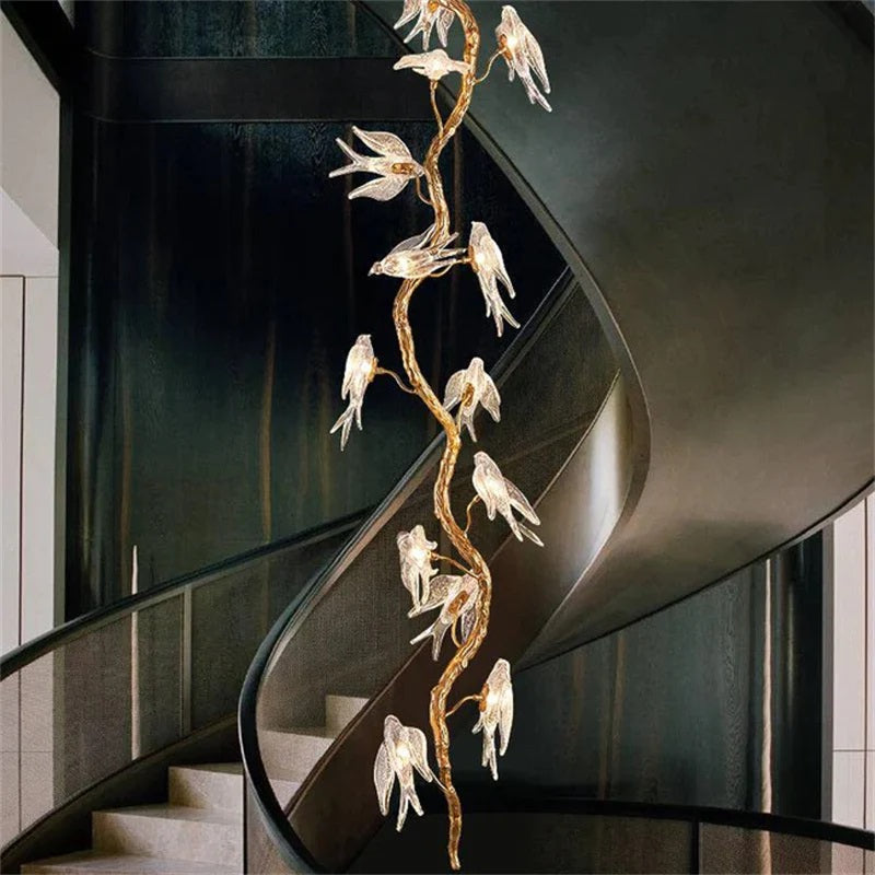 Bird Glass Branch Long Chandelier For Staircase is made of handmade brass and Bird shape glass. The brass frame is inspired by the surface of the organic tree, with the glass bird on the tree. Perfect for your Staircase.