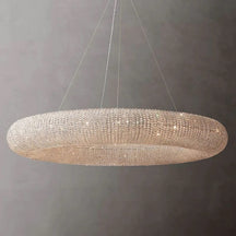 Hale Series chandeliers echo the originality of industrial design in the 1920s. Thousands of cut, hand wrapped crystal glass beads wrap around the steel frame to form a floating sphere suspended by steel cables. These beads reflect and refract the light in the room and cast a warm light.